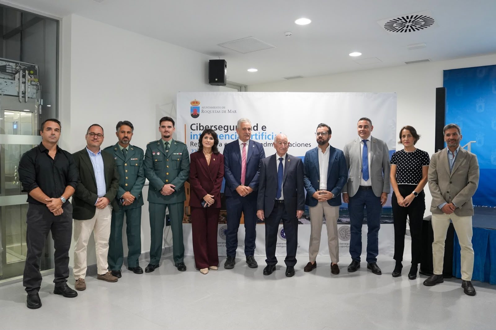 Foto de familia de autoridades, ponentes y participantes en la mesa redonda ante el photocall de la jornada «Ciberseguridad e inteligencia artificial» del Ayuntamiento de Roquetas de Mar, en el Edificio Polivalente El Puerto